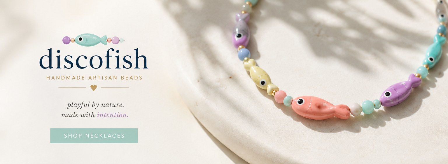 A pastel fish bead necklace in coral, lilac, mint and butter yellow, resting in sunlight beside the discofish wordmark.